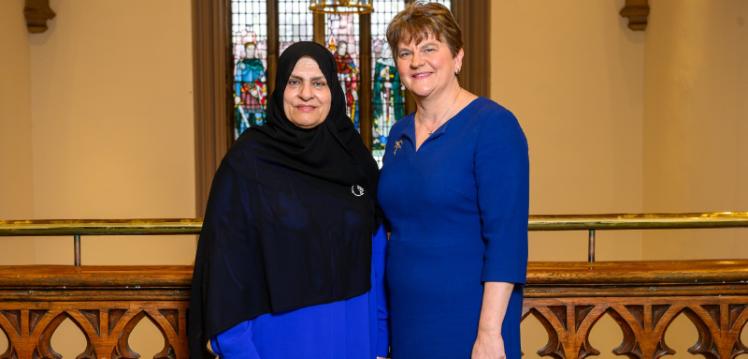 Two women - Her Excellency Dr Raja Al Gurg and Baroness Foster - stand in the hallway of a university looking at the camera